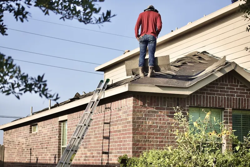 Professional roofer working on a residential roof in Stacy